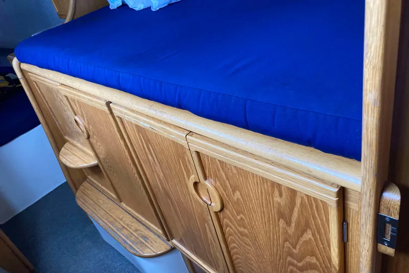 Slide: The Image of 2009 Seawind 36 1000XL interior with blue cushioned bed and wooden cabinetry. - 30