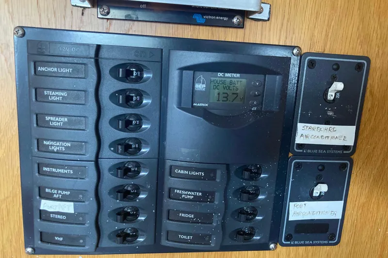 Slide: The Image of Electrical panel of a 2009 Seawind 36 1000XL with labeled switches and DC meter. - 38