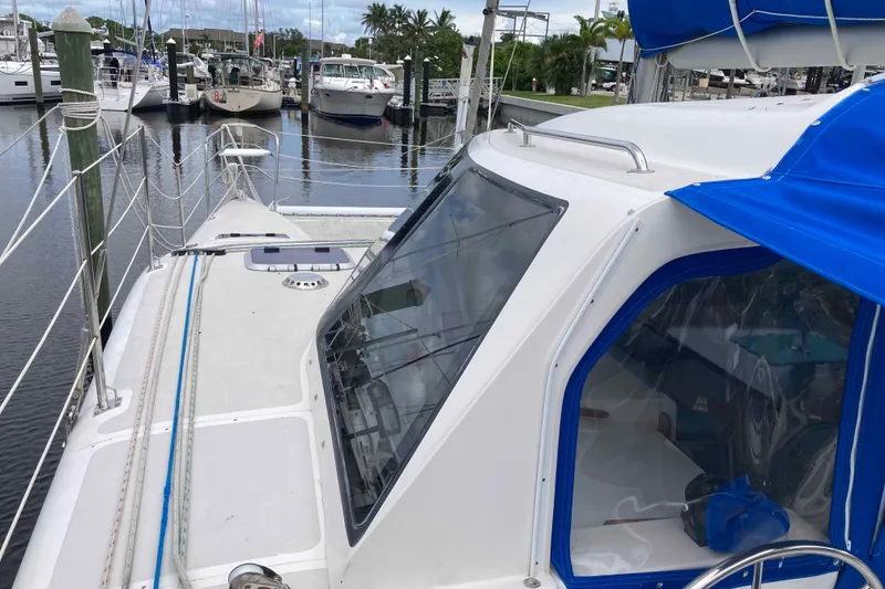 Slide: The Image of 2009 Seawind 36 1000XL catamaran docked, featuring blue canopy and sleek design. - 4