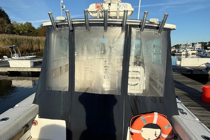 Slide: The Image of 2014 Steiger Craft 26' Miami boat docked, featuring a covered cabin and life preserver. - 5