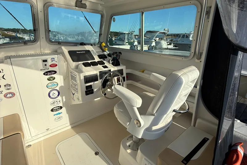 Slide: The Image of 2014 Steiger Craft 26' Miami boat interior with helm, steering wheel, and control panel. - 7