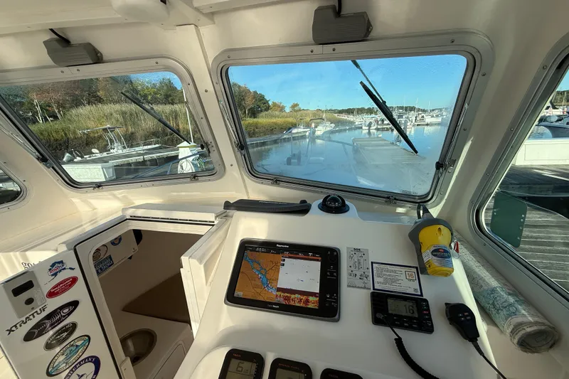 Slide: The Image of Steiger Craft 26' Miami 2014 boat interior with navigation equipment and marina view. - 9