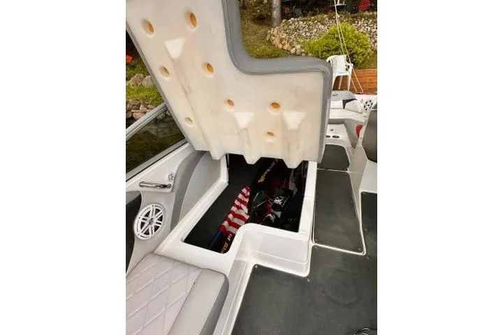 Slide: The Image of 2009 MasterCraft X-15 boat interior storage compartment with open seat and visible speaker. - 10