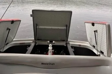 Slide: The Image of 2009 MasterCraft X-15 boat with open storage compartments on a calm lake. - 11