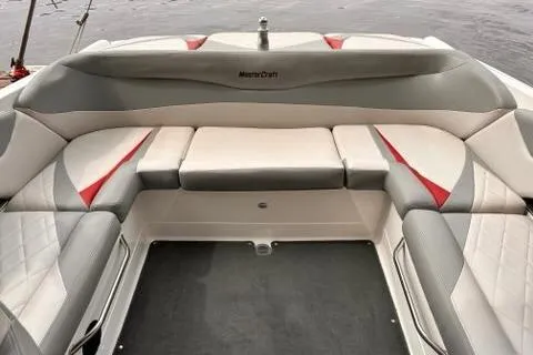 Slide: The Image of 2009 MasterCraft X-15 boat interior with gray and red seating, on calm water. - 18