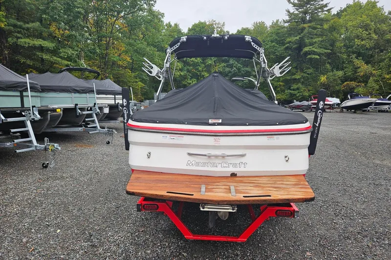 Slide: The Image of 2009 MasterCraft X-15 boat with cover, parked in a wooded area. - 23