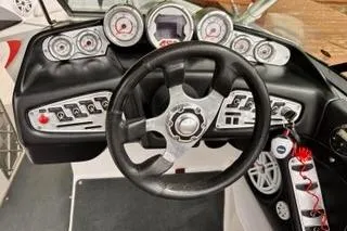 Slide: The Image of 2009 MasterCraft X-15 boat dashboard with steering wheel and control gauges. - 6