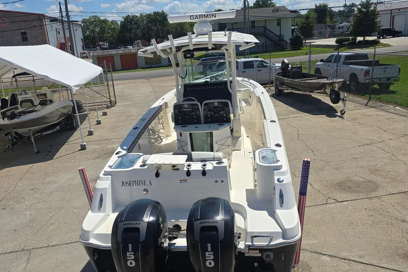 Slide: The Image of 2019 Wellcraft 262 Fisherman boat with twin Mercury 150 engines, parked outdoors. - 7