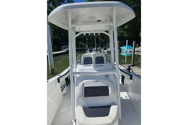 Slide: The Image of 2024 Tidewater 220 CC Adventure boat with T-top, docked in a marina. - 12