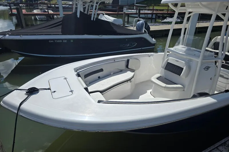 Slide: The Image of 2024 Tidewater 220 CC Adventure boat docked, featuring spacious seating and sleek design. - 5