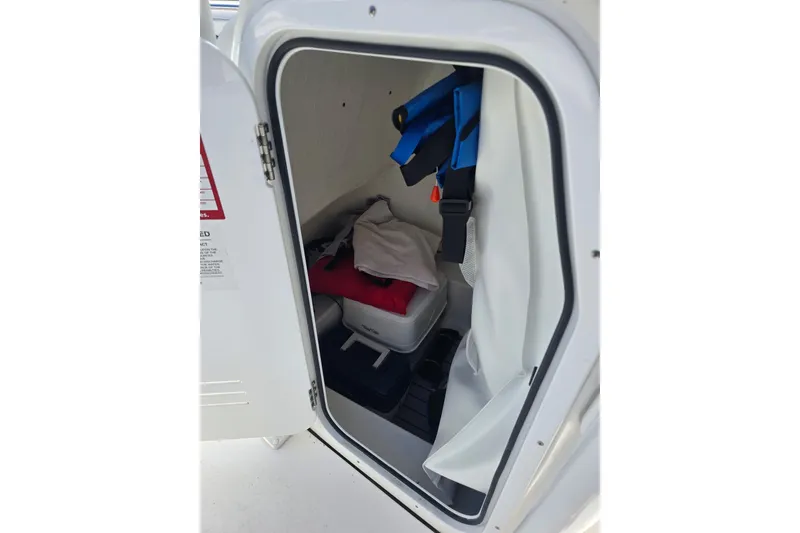 Slide: The Image of Storage compartment of 2024 Tidewater 220 CC Adventure boat with life jackets and cooler. - 7