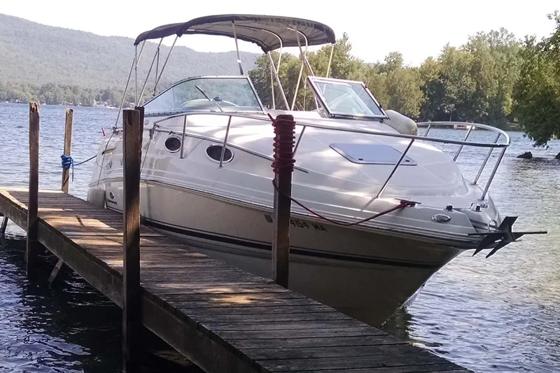 Slide: The Image of 2005 Chaparral Signature 260 boat docked on a serene lake with scenic mountain backdrop. - 2