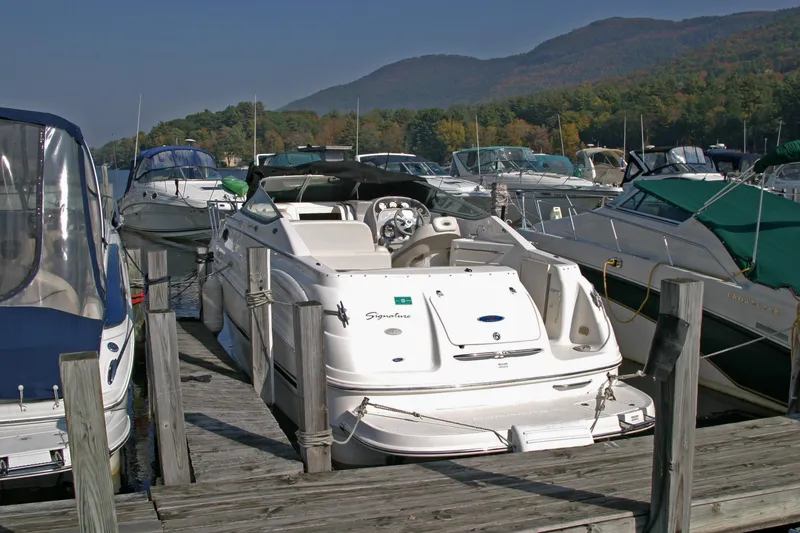 Slide: The Image of 2005 Chaparral Signature 260 boat docked at a marina with scenic mountain backdrop. - 4
