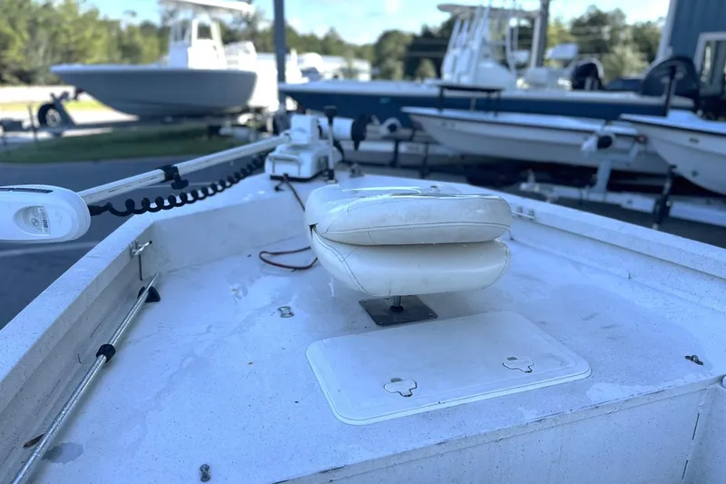 Slide: The Image of 2017 G3 Bay 18 DLX boat with white seating and trolling motor, docked outdoors. - 8