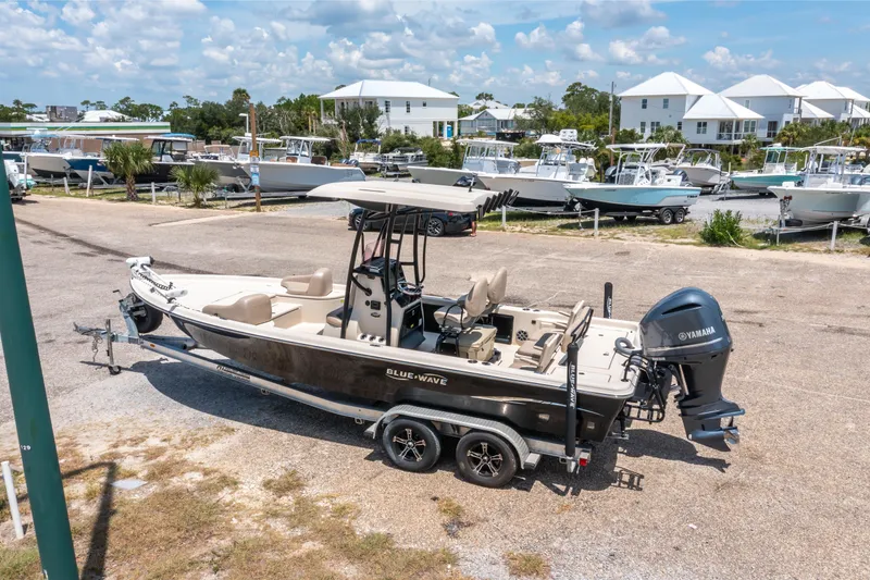 Slide: The Image of 2020 Blue Wave 2400 PureBay boat on trailer, parked in marina with other boats. - 3