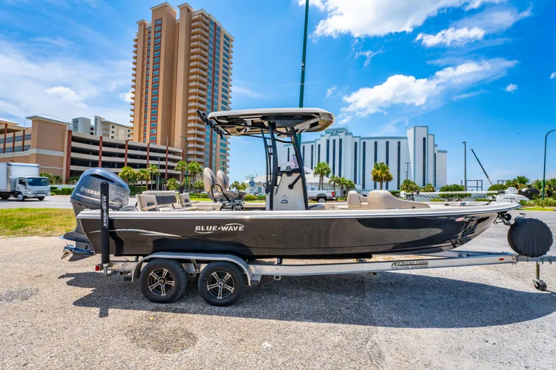 Slide: The Image of 2020 Blue Wave 2400 PureBay boat on trailer, urban background, clear sky. - 4