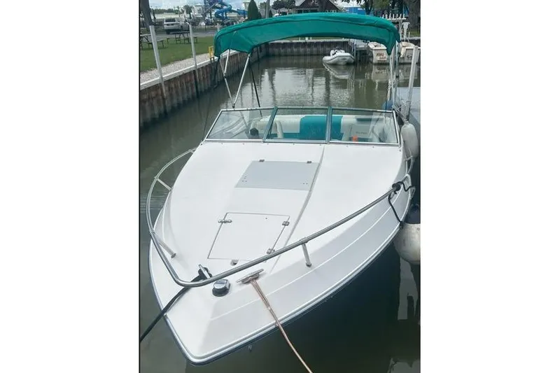 Slide: The Image of 1991 Wellcraft 216 Eclipse boat docked with green canopy and white hull. - 16