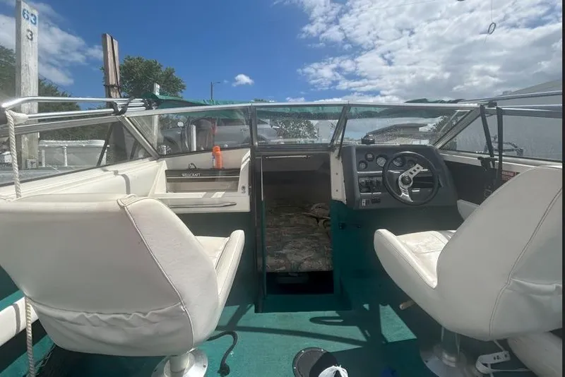 Slide: The Image of Interior of a 1991 Wellcraft 216 Eclipse boat with white seats and green carpet. - 5