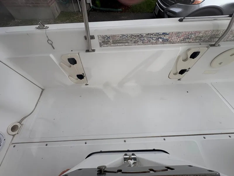 Slide: The Image of 2004 Boston Whaler 220 Dauntless boat interior with rod holders and map detail. - 7