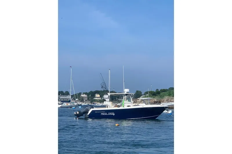 Slide: The Image of 2019 Sailfish 270 CC boat on calm water near a marina. - 23