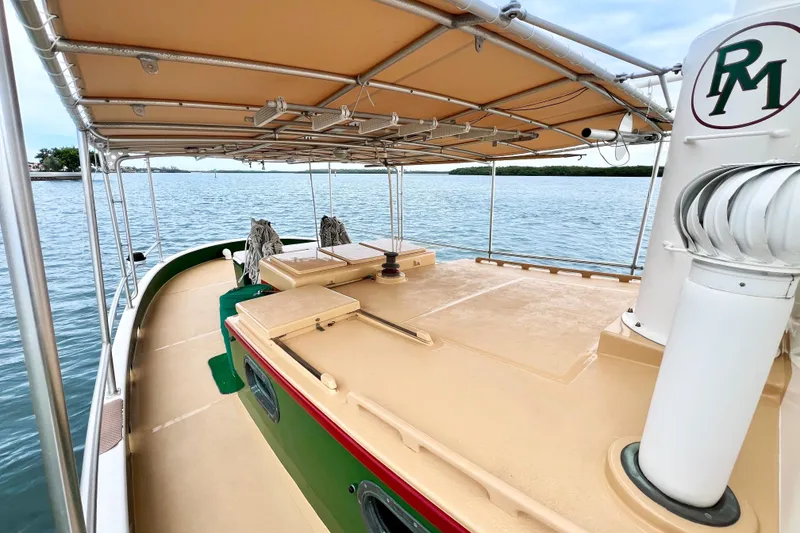 Slide: The Image of 1972 Mills Boat Works Tug Boat on calm water, featuring a covered deck and classic design. - 10