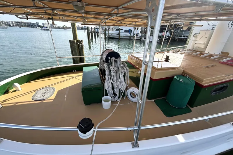 Slide: The Image of 1972 Custom Tug Boat deck with ropes, docked at marina, sunny day. - 12