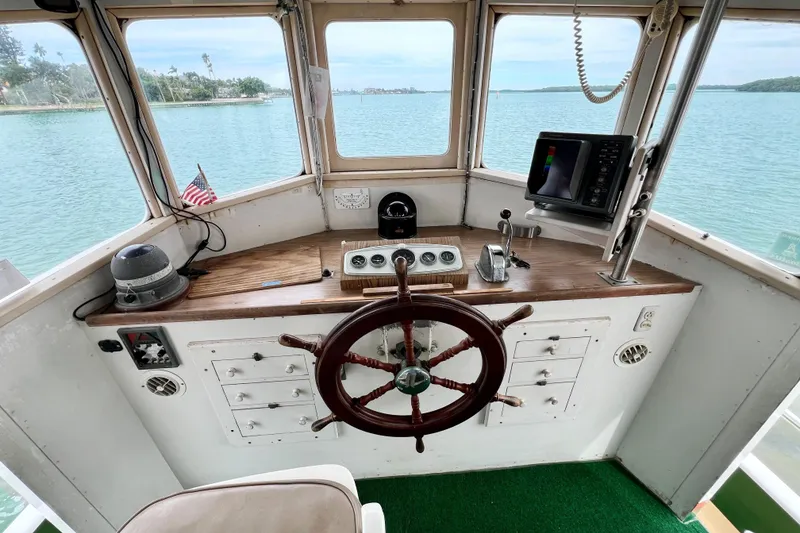 Slide: The Image of 1972 Mills Boat Works Tug Boat helm with wooden wheel and navigation equipment. - 15