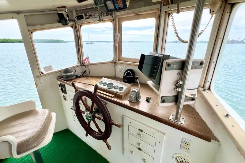 Slide: The Image of Interior of a 1972 Mills Boat Works Tug Boat with steering wheel and navigation equipment. - 16