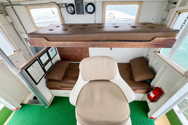 Slide: The Image of 1972 Mills Boat Works Tug Boat interior with seating, cushions, and control panel. - 17