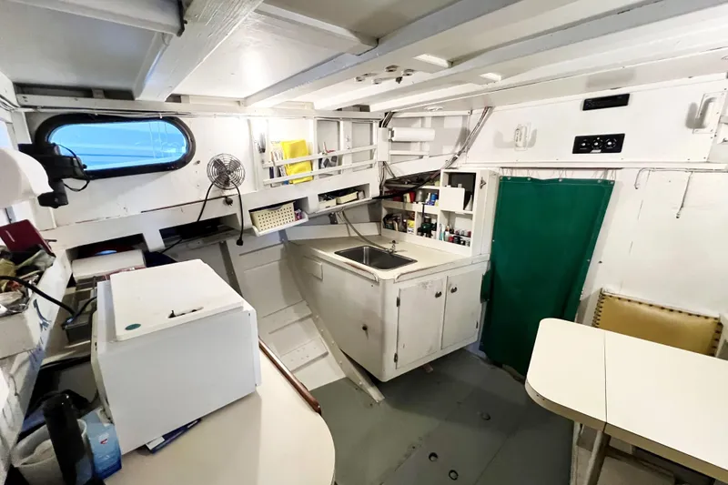 Slide: The Image of Interior of a 1972 Mills Boat Works Tug Boat with kitchenette and seating area. - 18