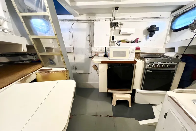 Slide: The Image of 1972 Mills Boat Works Tug Boat interior with kitchen appliances and dining area. - 19