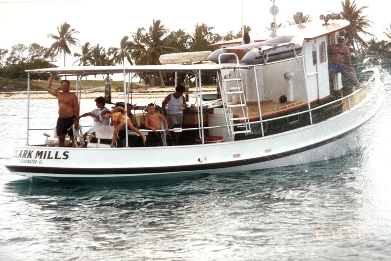 Slide: The Image of Custom 1972 tug boat with people onboard, near tropical island and palm trees. - 29