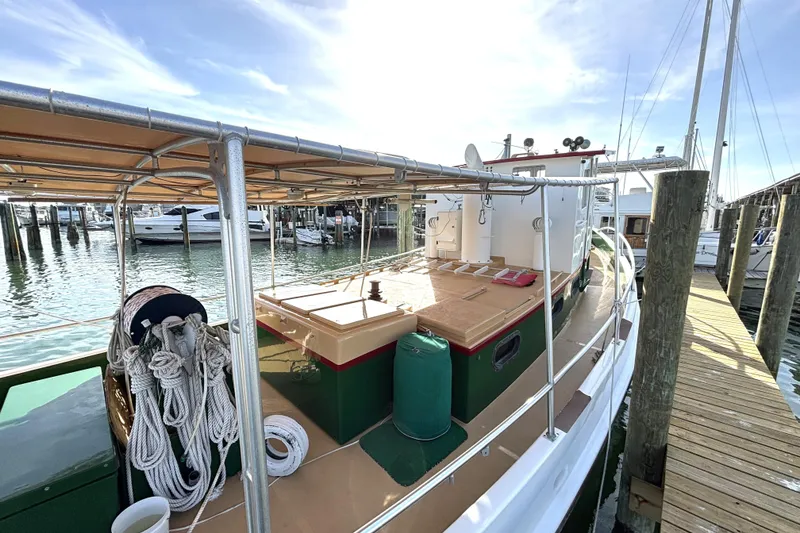 Slide: The Image of Custom 1972 tug boat docked at marina, featuring ropes and covered deck. - 9