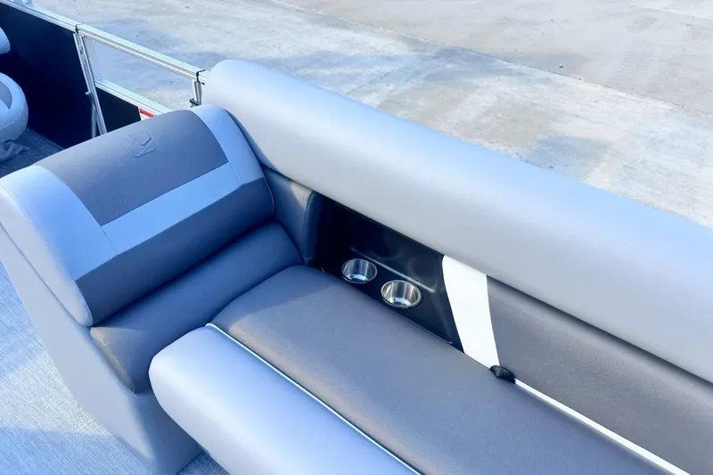 Slide: The Image of 2026 Landau Island Breeze 25 boat seating with cup holders, featuring sleek gray upholstery. - 12