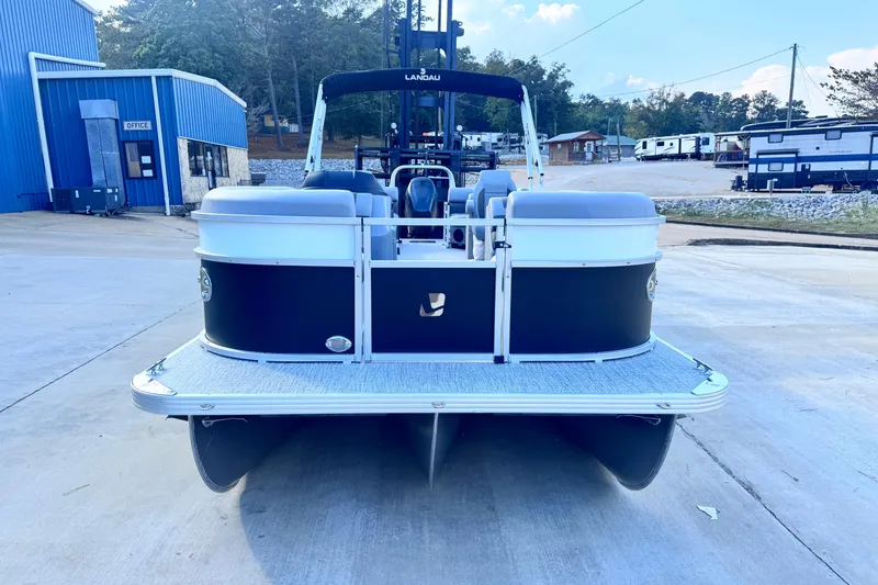 Slide: The Image of 2026 Landau Island Breeze 25 pontoon boat parked at a marina. - 2