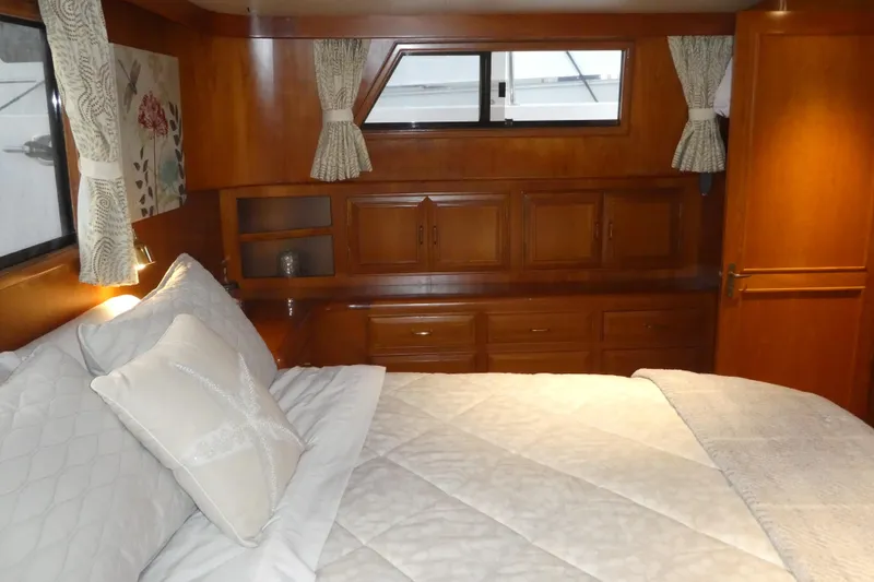 Slide: The Image of Cozy bedroom interior of 1992 Ocean Alexander 456 Classicco yacht with wood paneling and soft bedding. - 32