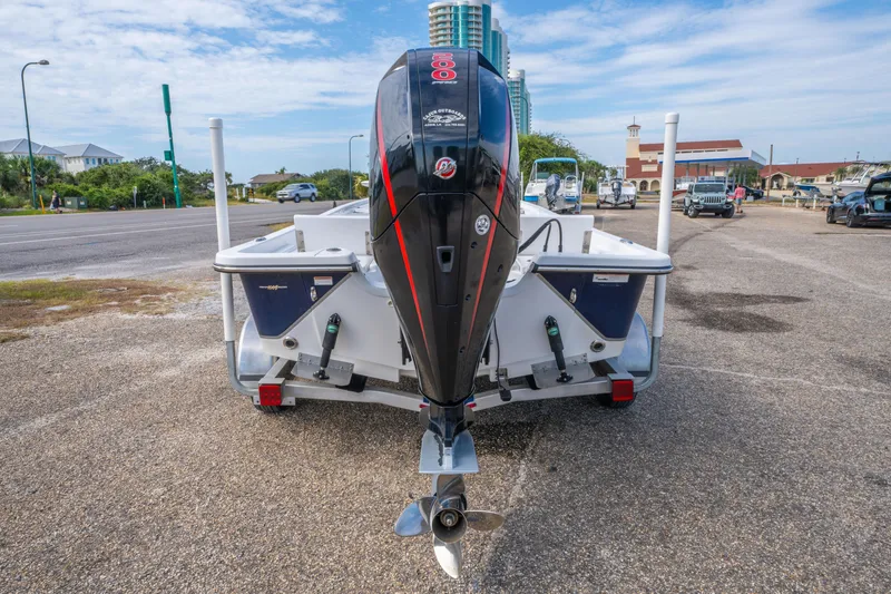 Slide: The Image of 2021 Blazer Bay 2200 boat with outboard motor in a parking lot. - 11