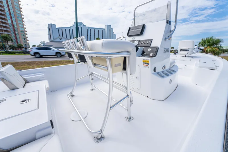 Slide: The Image of 2021 Blazer Bay 2200 boat interior with console and seating, near buildings and road. - 15