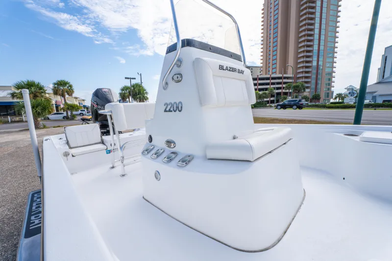 Slide: The Image of 2021 Blazer Bay 2200 boat with seating, parked near a city street. - 17