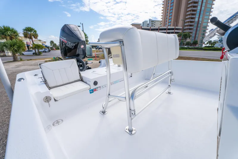 Slide: The Image of 2021 Blazer Bay 2200 boat interior with seating and motor, urban backdrop. - 18