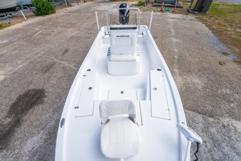 Slide: The Image of 2021 Blazer Bay 2200 boat, white interior, parked on concrete surface. - 23