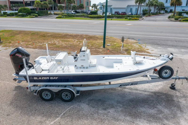 Slide: The Image of 2021 Blazer Bay 2200 boat on trailer, parked near a road. - 3
