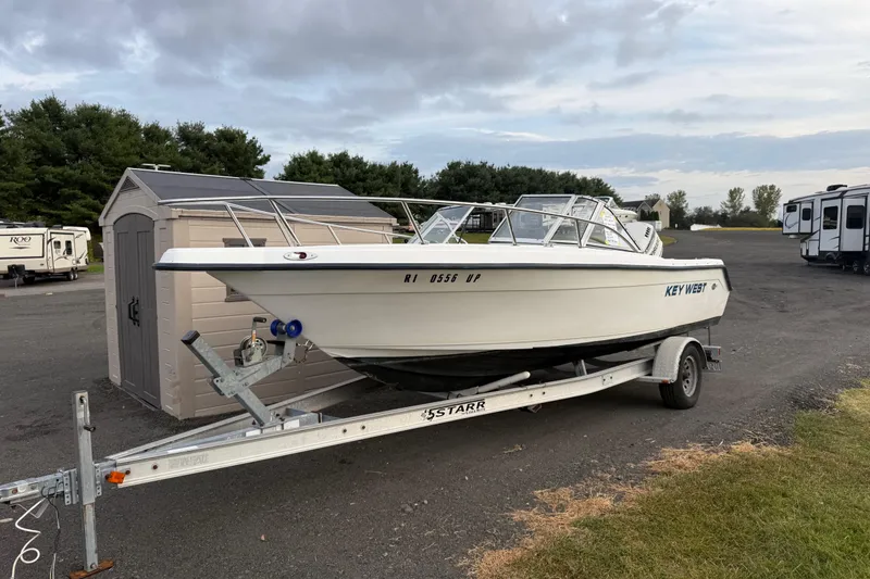 The Image of Key West 2020 Dual Console boat on trailer, parked near shed and RVs. - 1
