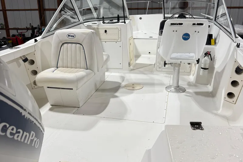 Slide: The Image of Interior of a 2000 Key West 2020 Dual Console boat, featuring white seating and steering area. - 7