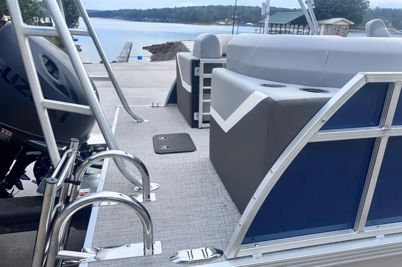 Slide: The Image of 2026 Landau ISLAND BREEZE 21 pontoon boat interior with seating and ladder, near a serene lake. - 14
