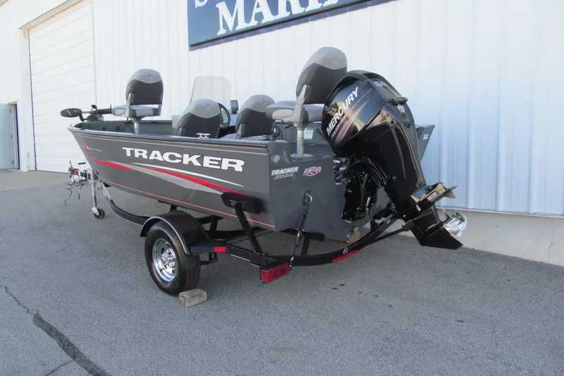 Slide: The Image of 2016 Tracker Pro Guide V-16 SC boat with outboard motor, parked outdoors. - 3
