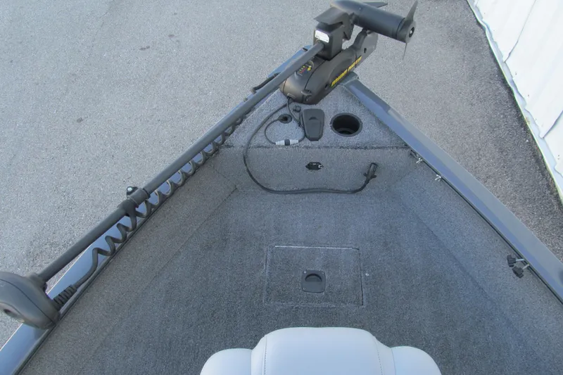 Slide: The Image of 2016 Tracker Pro Guide V-16 SC boat interior with trolling motor and carpeted deck. - 6