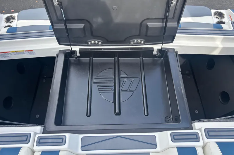 Slide: The Image of 2025 Malibu Wakesetter 22 MXZ storage compartment with open lid, showcasing interior design. - 16