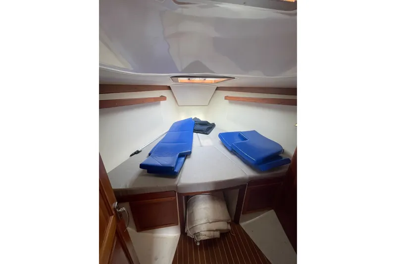 Slide: The Image of Cozy cabin interior of 2002 Tartan 37 sailboat with blue cushions and wooden accents. - 11