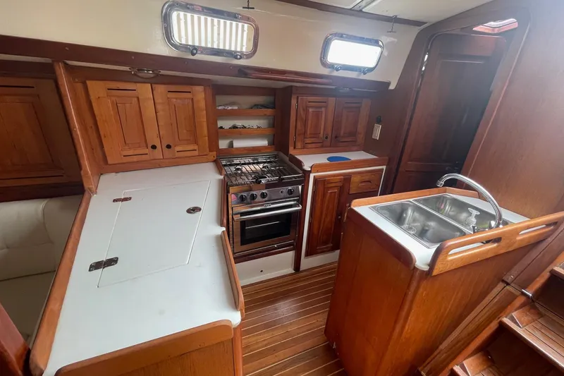 Slide: The Image of Interior of 2002 Tartan 37 sailboat kitchen with wooden cabinetry and stainless steel sink. - 15